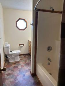 a bathroom with a toilet and a bath tub at Solarium Cabin #16 on Patoka Lake in Southern Indiana in Seymour