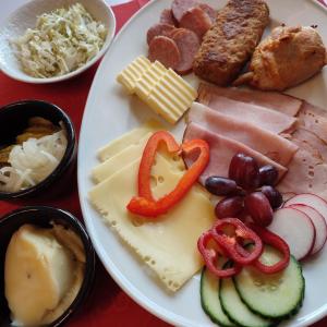 eine Platte mit Käse, Fleisch und anderen Lebensmitteln in der Unterkunft Berggasthof Kuhberg in Stützengrün