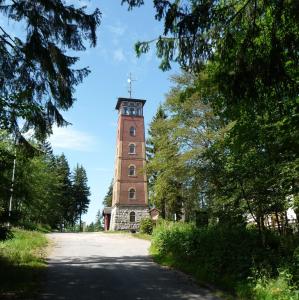 ein hoher Backsteinturm, der auf einer Straße sitzt in der Unterkunft Berggasthof Kuhberg in Stützengrün