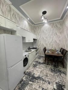 a kitchen with a table and a white refrigerator at City Plaza Krenkel in Navakhchinan