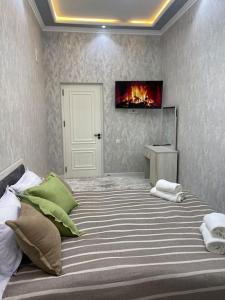 a bedroom with a bed with a fireplace on the wall at City Plaza Krenkel in Navakhchinan