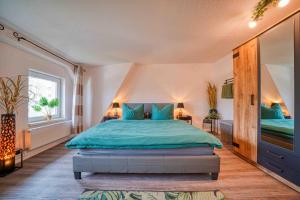 ein Schlafzimmer mit einem großen Bett mit blauen Kissen in der Unterkunft Zuarin Schlossblick - Ganzes Apartment direkt am Schlossgarten von Schwerin mit Dschungel-Feeling - Parkplatz auf Anfrage vorhanden in Schwerin