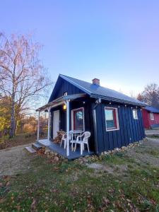 una casita azul con una mesa y sillas. en Self Check-in Sauna Cabin next to Hiking Trails, en Kärde