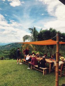 eine Gruppe von Menschen, die an einem Picknicktisch sitzen in der Unterkunft Hacienda La Mesa - Coffee farm in La Paloma