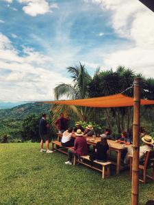 un grupo de personas sentadas en una mesa de picnic en Hacienda La Mesa - Coffee farm, en La Paloma