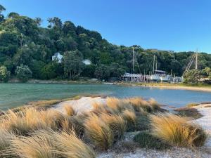 un cuerpo de agua con hierba alta en la orilla en Your home at Cockle Bay en Auckland