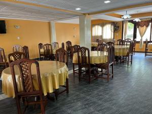 ein Esszimmer mit Tischen und Stühlen sowie einem gelben Tischtuch in der Unterkunft Hotel Santander in Termas de Río Hondo + 4 Fotos