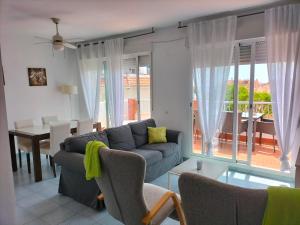 a living room with a couch and a table with chairs at ApartiaBeach Apartamentos in Alcossebre