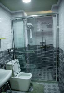 a bathroom with a shower and a toilet and a sink at One Love Hotel in Kigali