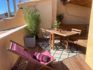 Elle comprend un petit balcon avec une table et des chaises en bois. dans l'établissement Le Mini - Un voyage en Provence, à Aix-en-Provence