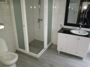 ein Bad mit einer Dusche, einem WC und einem Waschbecken in der Unterkunft One Love Hotel in Kigali
