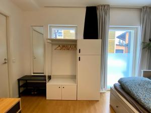 a bedroom with a white cabinet and a bed at Tranquil studio near nature, free parking& wifi in Helsinki