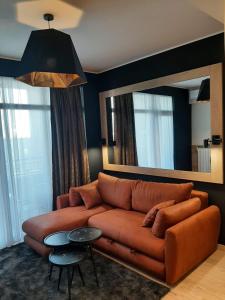 a living room with a brown couch and a mirror at Belgrade Waterfront Lux Studio Apartment in Belgrade