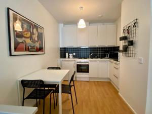 a kitchen with white cabinets and a table and chairs at Tranquil studio near nature, free parking& wifi in Helsinki