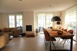 a living room with a table and a couch at Golden Wellness Villa Noordwijk in Noordwijk