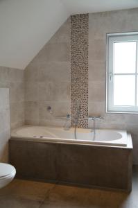 a bathroom with a bath tub and a window at Golden Wellness Villa Noordwijk in Noordwijk +28 photos