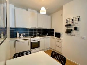 a kitchen with white cabinets and a table and chairs at Tranquil studio near nature, free parking& wifi in Helsinki