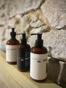 three bottles of soap sitting on a wooden shelf at Chaloupka Kunčice in Staré Město