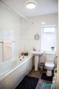 a bathroom with a tub and a toilet and a sink at Liverpool City Flat 4 by Sheryl - Close to City Center, Anfield Stadium and Airport with free business super fast fibre broadband in Liverpool