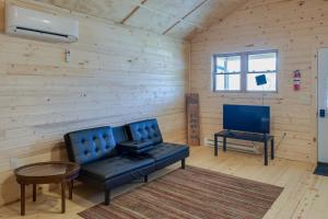 ein Wohnzimmer mit einem blauen Sofa und einem TV in der Unterkunft Riverfront Cabin Rental about 9 Mi to Yellowstone Lake 