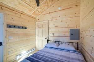 ein Schlafzimmer mit einem Bett in einer Holzhütte in der Unterkunft Riverfront Cabin Rental about 9 Mi to Yellowstone Lake 
