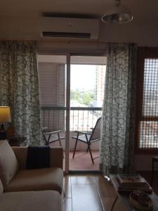 ein Wohnzimmer mit einem Sofa und einem Balkon in der Unterkunft Best location ! Apt priv de 2 hab c AC Completamente equipado en Asuncion in Asunción