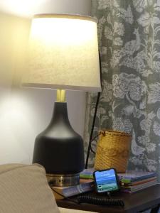 une lampe assise sur une table à côté d'un lit dans l'établissement Best location ! Apt priv de 2 hab c AC Completamente equipado en Asuncion, à Asuncion
