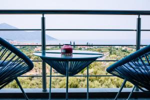 een tafel en twee stoelen voor een raam bij Konatsi Luxury Apartments in Tiros