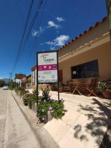 znak na boku budynku z kwiatami w obiekcie La Morada Hostal w mieście Cafayate