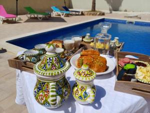 een tafel met een buffet van eten naast een zwembad bij DAR EL JERBIA in Midoun