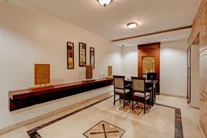 un vestíbulo con un bar con sillas y una mesa en OYO Palette - Hotel Victoria, en Chennai
