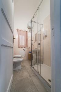 La salle de bains est pourvue d'une douche en verre et de toilettes. dans l'établissement Voilà Rooms Guest House, à Terrasini