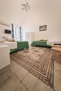 - une chambre avec 2 lits et un tapis dans l'établissement Voilà Rooms Guest House, à Terrasini