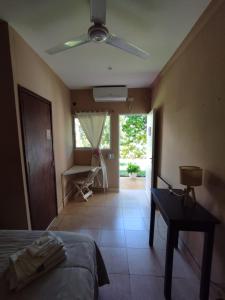 1 dormitorio con 1 cama y ventilador de techo en La Morada Hostal en Cafayate