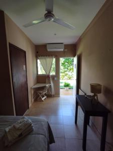 a bedroom with a bed and a ceiling fan at La Morada Hostal in Cafayate