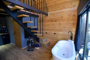 a bathroom with a tub and a staircase in a house at Kazbegi Story in Stepantsminda