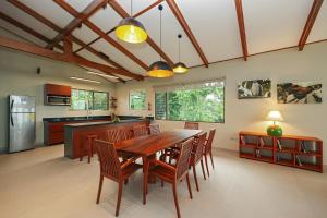 a kitchen and dining room with a wooden table and chairs at Arenal Observatory Lodge & Trails in Fortuna