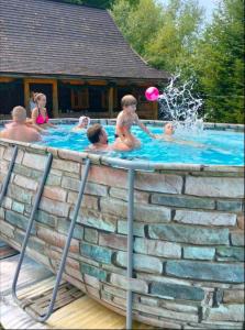 a group of people playing in a swimming pool at Stara Khata Карпати in Sheshory