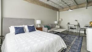 a bedroom with a bed and a couch and a table at Landing Modern Apartment with Amazing Amenities (ID1803X66) in Mobile