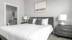 een witte slaapkamer met een groot bed en 2 lampen bij Landing Modern Apartment with Amazing Amenities (ID1802X54) in Austin