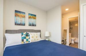 um quarto com uma cama azul com três pinturas na parede em Landing Modern Apartment with Amazing Amenities ID1804X58 em St. Petersburg
