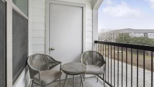 2 sillas y una mesa en el balcón en Landing Modern Apartment with Amazing Amenities ID1802X97, en Haltom City