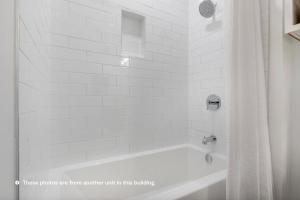 El baño incluye bañera blanca con cortina de ducha. en Landing Modern Apartment with Amazing Amenities (ID1804X64), en Bee Cave