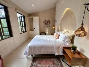 1 dormitorio con cama, mesa y ventanas en Loft Amalfi en Val'Quirico, en Santeagueda