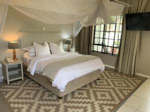 a bedroom with a large bed with white sheets and pillows at The Leslie - Bed & Breakfast in Blantyre