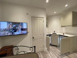 a kitchen with a flat screen tv on the wall at Luxury 6 Bedroom House, all with En-suite bathroom - West London - Wembley Stadium, OVO Arena 5 km in Greenford