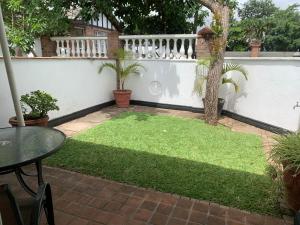 a small yard with a white fence and grass at The Leslie - Bed & Breakfast in Blantyre