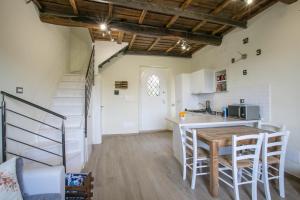 une cuisine et une salle à manger avec une table et un escalier dans l'établissement DOLCE VITA, à Vignanello