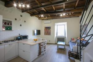 - une cuisine avec des placards blancs et une table dans une pièce dans l'établissement DOLCE VITA, à Vignanello