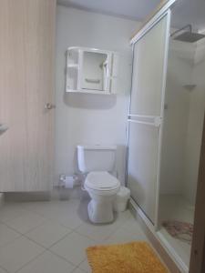 een witte badkamer met een toilet en een douche bij posada sunrise view vacation home in Providencia
